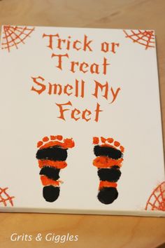 a trick or treat smell my feet sign is displayed on a wooden table with an orange and black design