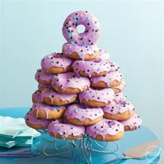 a stack of doughnuts with pink frosting and sprinkles on top