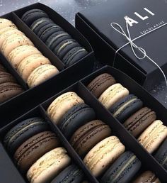 an open box of macaroons sitting on top of a table next to each other