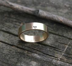 a ring with a heart on it sitting on top of a piece of wooden plank