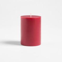 a red candle is sitting on a white surface