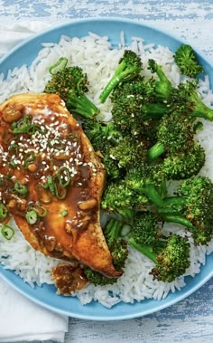 a blue plate topped with rice and broccoli covered in teriyaki sauce