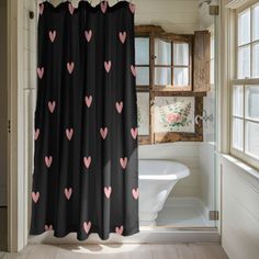 a shower curtain with pink hearts on it in front of a bathtub and window