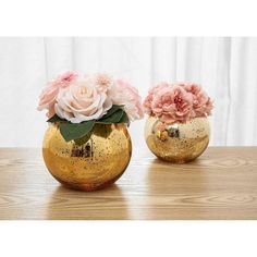 two gold vases with pink flowers in them