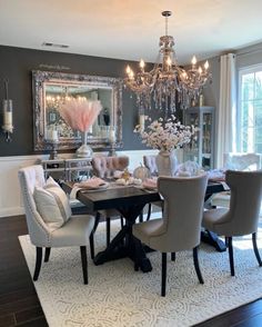 a dining room table and chairs with chandelier in the middle, along with an area rug on the floor