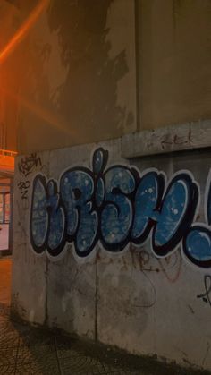 a wall covered in graffiti next to a street light