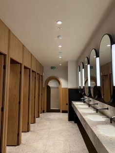 a row of sinks sitting next to each other in a room with mirrors on the wall