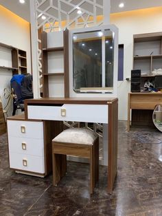 a white desk with drawers and a mirror on top of it in a room that has other furniture