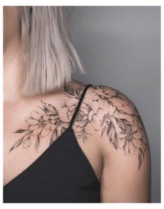 a woman's shoulder with flowers and leaves on the back of her neck,