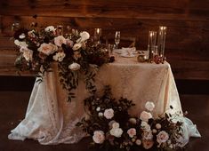 the table is set with flowers and candles for an elegant wedding reception in rustic style