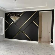 an empty room with a chandelier hanging from the ceiling and marble flooring