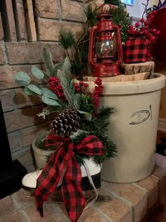 christmas decorations in buckets on brick fireplace with pine cones and red berries tied to them