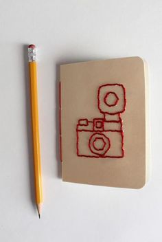 a drawing of a camera with a pencil next to it