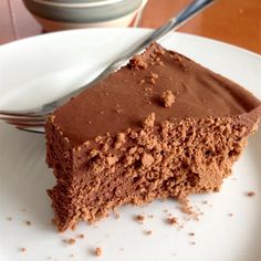 a piece of chocolate cake sitting on top of a white plate next to a fork