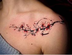 a woman's shoulder with red flowers and black ink on her left side breast