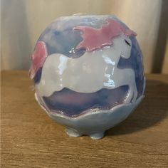 a small ceramic animal sitting on top of a wooden table