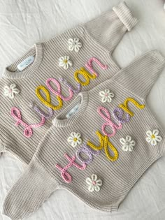 two knitted sweaters with flowers and the word love written in large letters on them