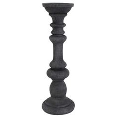 a tall black candle holder sitting on top of a table