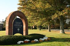 the entrance sign to saint anselm college in front of some trees and grass