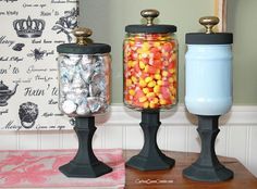 three jars filled with candy sitting on top of a table