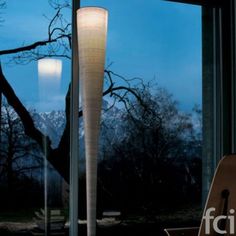 a floor lamp sitting in front of a window