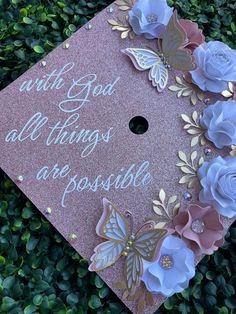 a pink and gold graduation cap with flowers on it that says, with god all things are possible