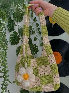 a crocheted purse with a flower on the front and side hanging from it