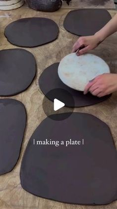 a person is making pizza dough on top of black plates with words that read i make a plate