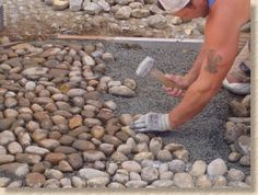 a man working on some rocks with a hammer