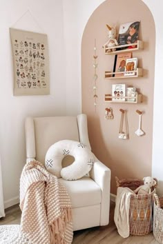 a white chair sitting in a room next to a shelf filled with books and toys