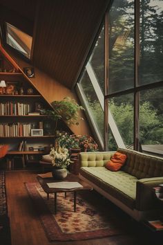 a living room filled with furniture and lots of windows next to a book shelf full of books