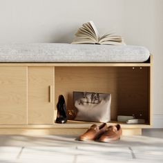 a book and shoes are on the floor next to a shelf with a book open