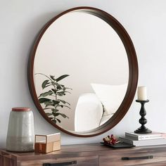 a round mirror sitting on top of a wooden dresser