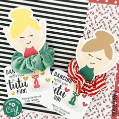 two paper dolls sitting next to each other on top of a striped tablecloth with candy canes