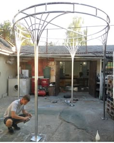 a man kneeling down in front of a metal structure