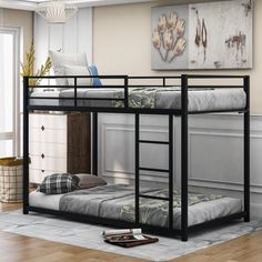 a black bunk bed sitting on top of a hard wood floor next to a window