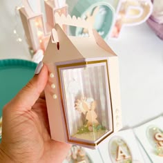 a person holding up a small box with a little fairy on it's side