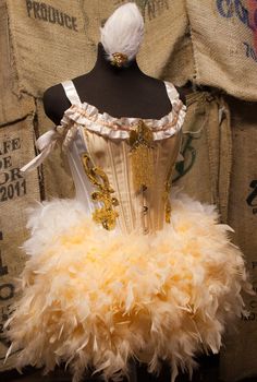 a mannequin is dressed up in a dress made out of feathers and beads