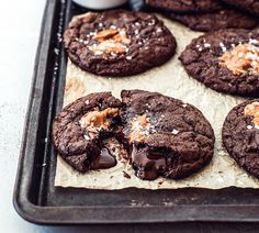 chocolate cookies with sea salt and caramel are on a baking sheet, ready to be eaten