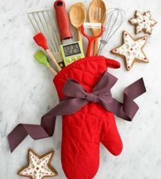 a red oven mitt with utensils and cookies in it sitting on a counter