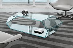 a glass coffee table sitting on top of a carpeted floor next to a chair