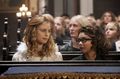 two women sitting next to each other in front of a group of people at a church