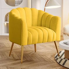 a yellow chair sitting on top of a hard wood floor next to a white table