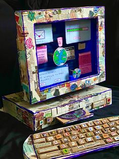 an old computer is decorated with stickers and paper mache pieces to make it look like the keyboard was made out of newspaper