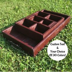 a wooden box sitting in the grass on top of it's side with four compartments