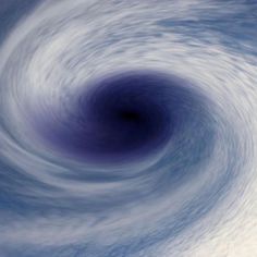 an image of a blue and white swirl in the sky with some clouds around it