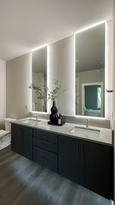 a large bathroom with two sinks and mirrors