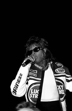 a black and white photo of a woman singing into a microphone