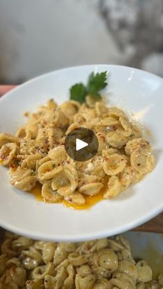 a white plate topped with pasta covered in sauce