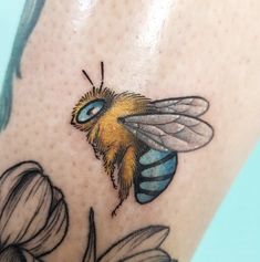 a close up of a tattoo with a bee on it